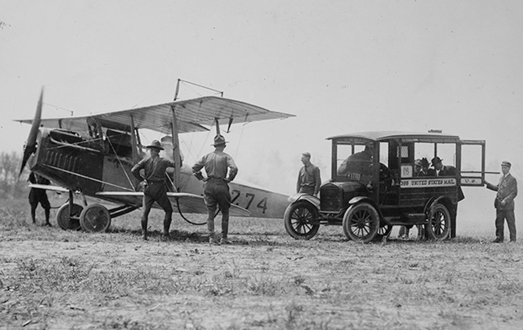 Mail is loaded onto a Curtiss JN-4H "Jenny" biplane, May 15, 1918, at Bustleton Field near Philadelphia, while U.S. Army personnel look on