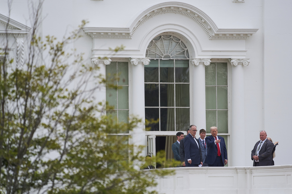 President Donald Trump with architect James McCrery, center, surveys the grounds from the roof above the Colonnade that goes to the West Wing of the White House