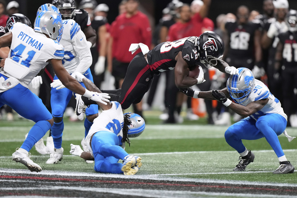 Detroit Lions safety Morice Norris (26) is hit in the helmet by Atlanta Falcons running back Nathan Carter (38) during the second half of an NFL preseason football game