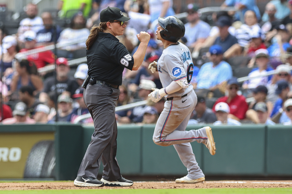 Umpire Jen Pawol, left, signals Miami Marlins