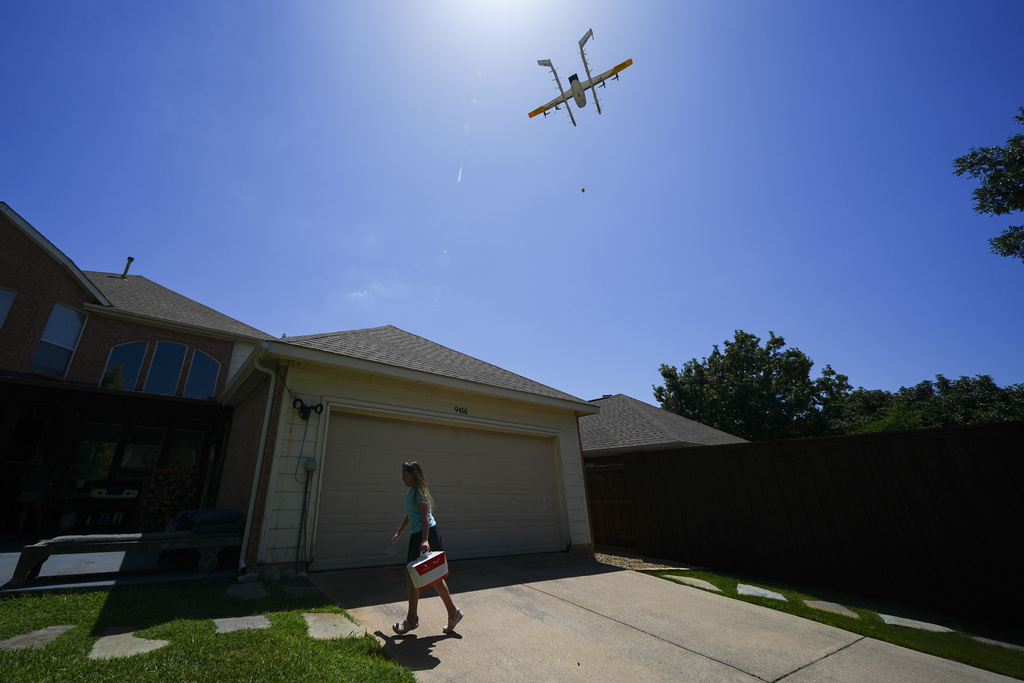 Julep Toth, 9, carries a package delivered to her house via a drone