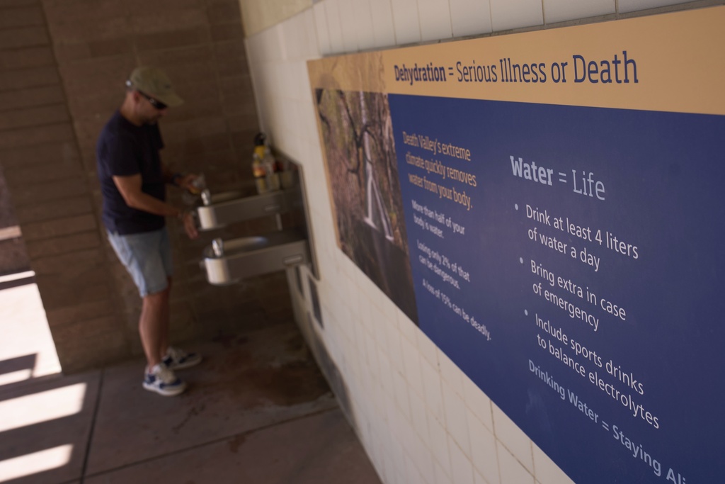 Pedro Luque, of Spain, fills up water bottles at the Furnace Creek Visitor Center in Death Valley National Park