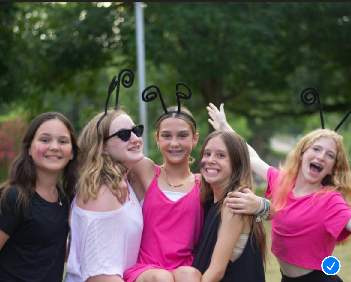 Five teen girls smile and pose for a picture at Camp Mystic