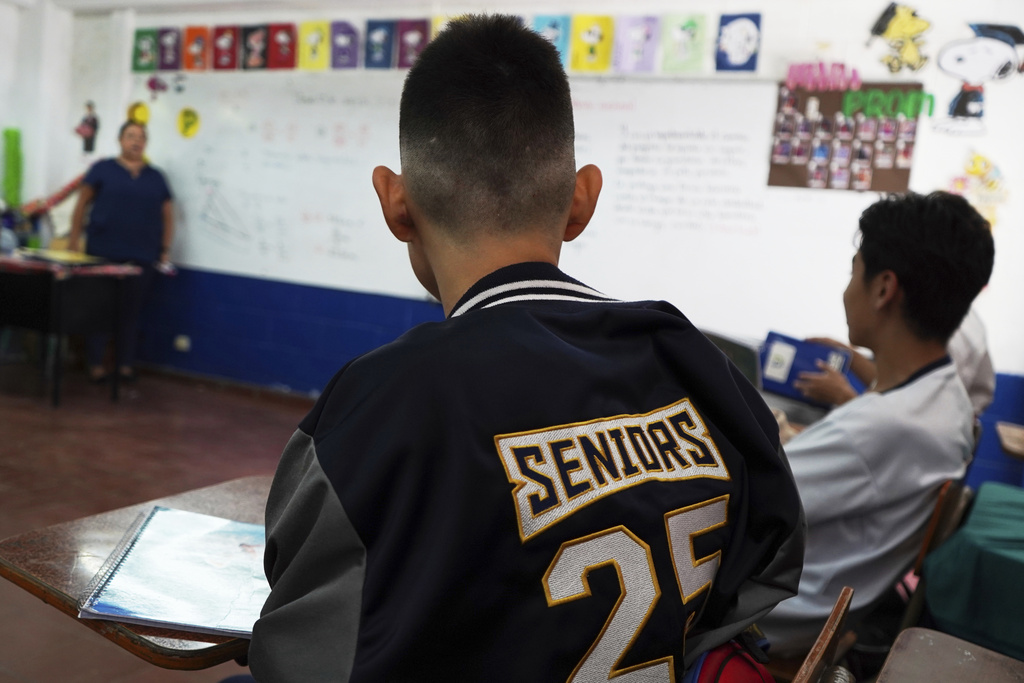 Student with freshly cut hair sits in class at a public school in San Salvador
