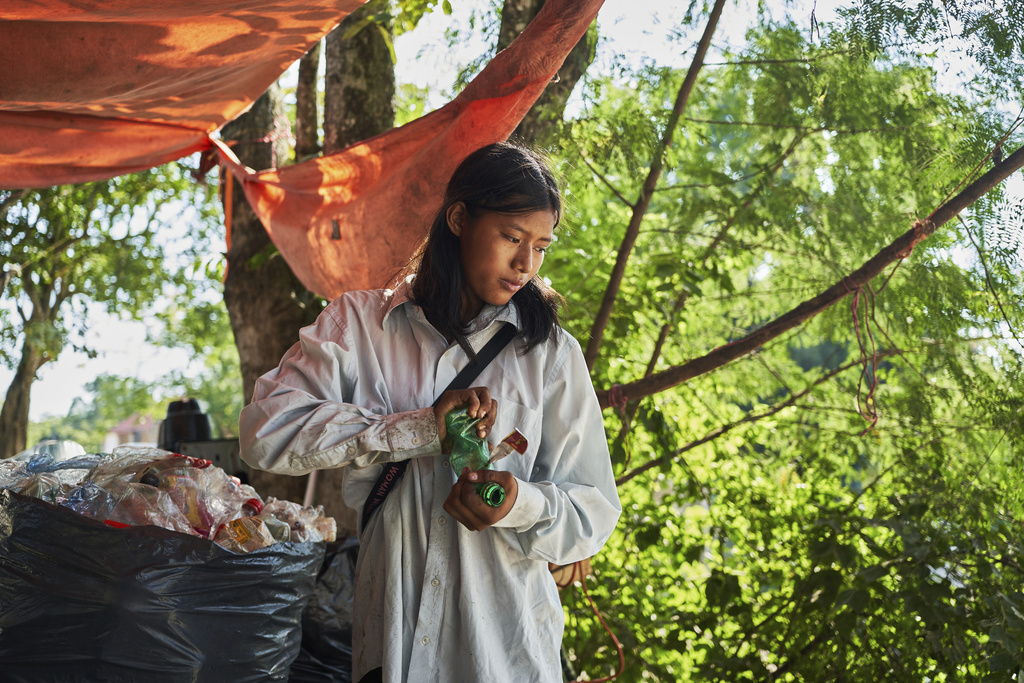 Isela Santiago Morales, who works with her family collecting PET bottles, sorts recyclables at the municipal dump in Axtla de Terrazas, Mexico