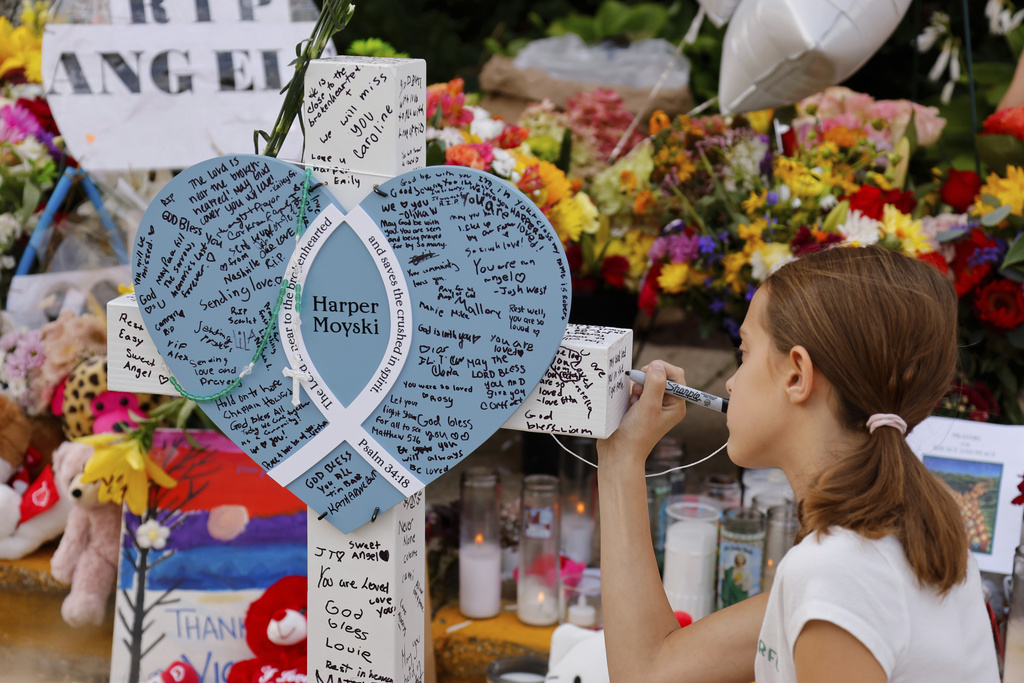 Kids write messages at make-shift memorial at Annunciation Catholic Church