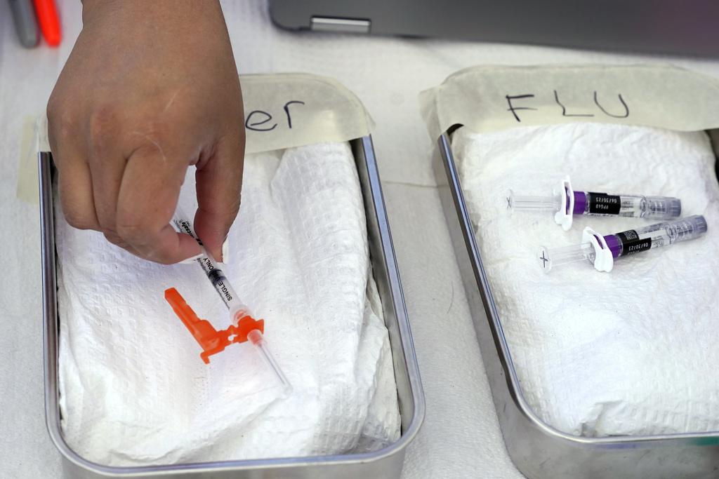 COVID vaccine, left, is readied as a flu vaccine sits nearby at the L.A. Care and Blue Shield of California Promise Health Plans