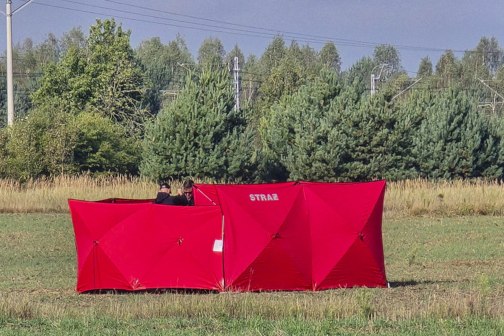 Firefighters secure parts of a damaged UAV shot down by Polish authorities at a site in Czosnowka near Biala Podlaska, Poland