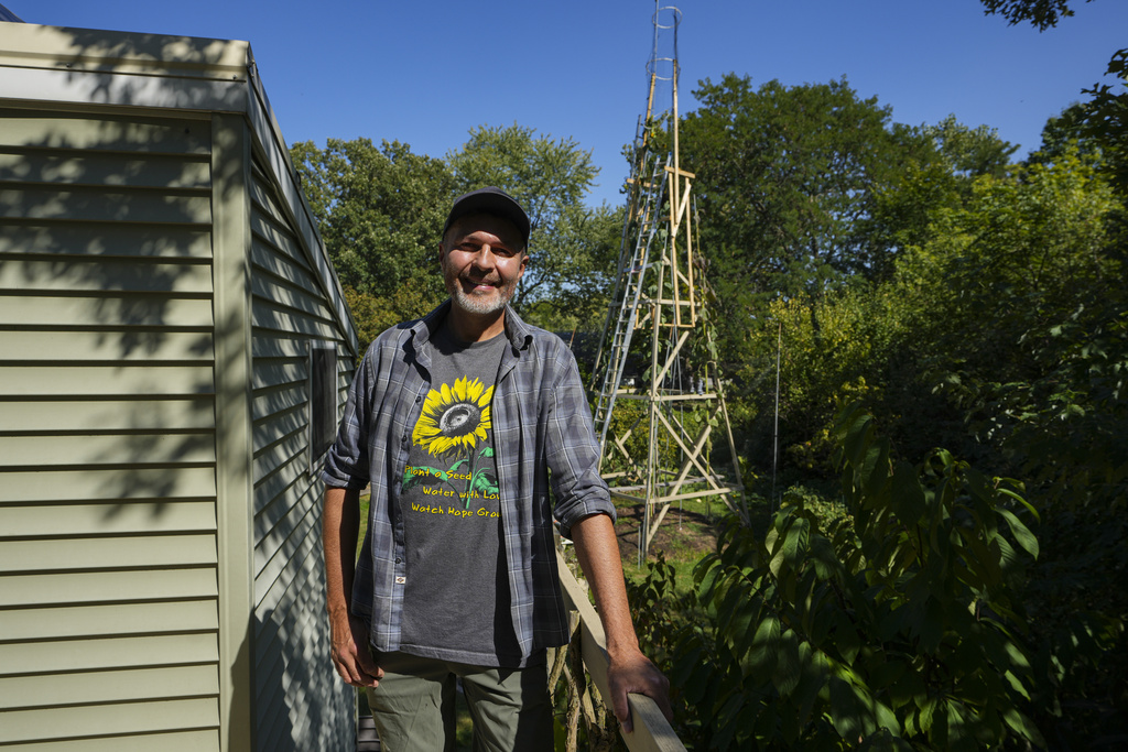 Alex Babich in front of the structure that surrounds his nearly 36-feet high sunflower