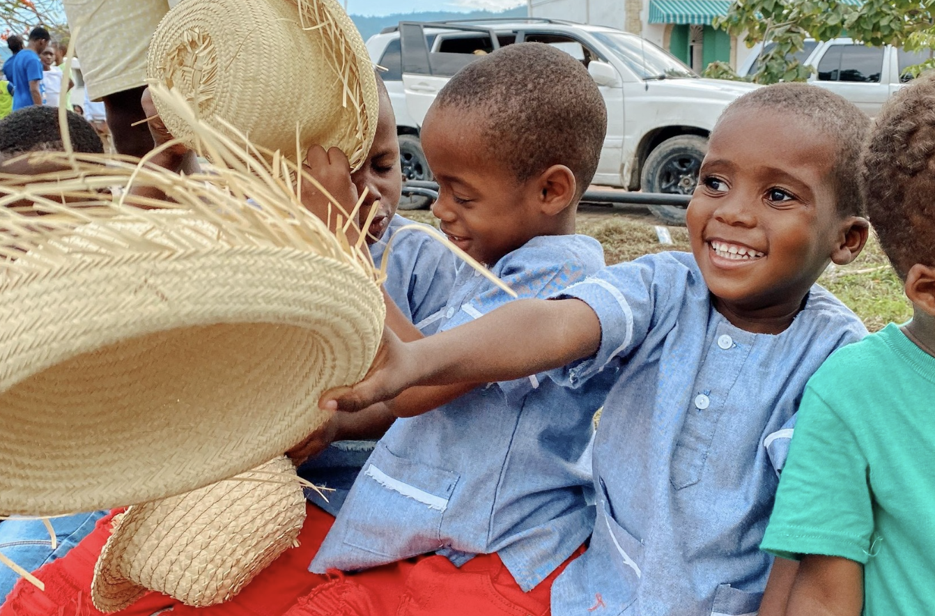 Four little boys with red pants and blue shirts, smiling