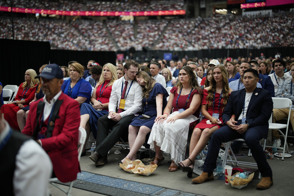 People listen as Erika Kirk speaks at a memorial for her late husband