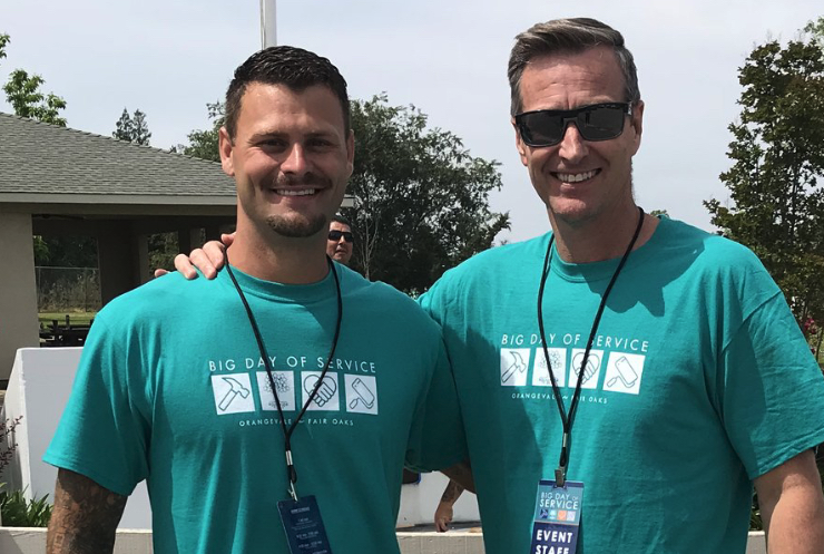 Two men smiling, outside