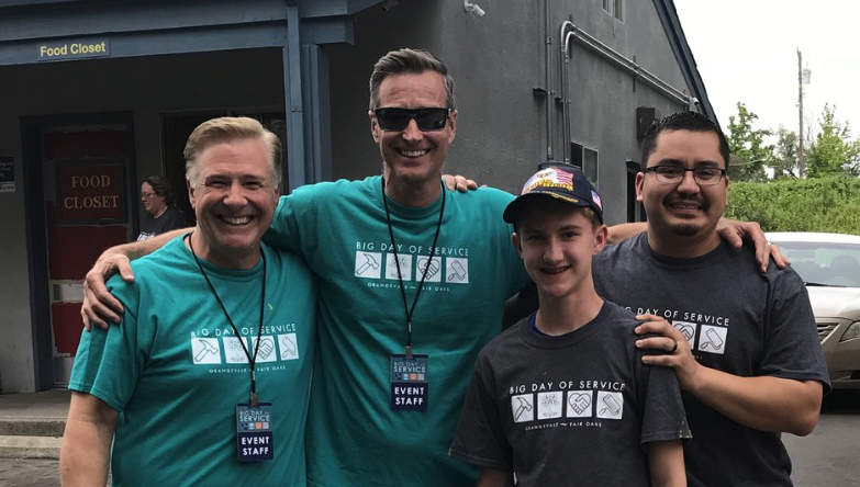 Three men and one young man, smiling