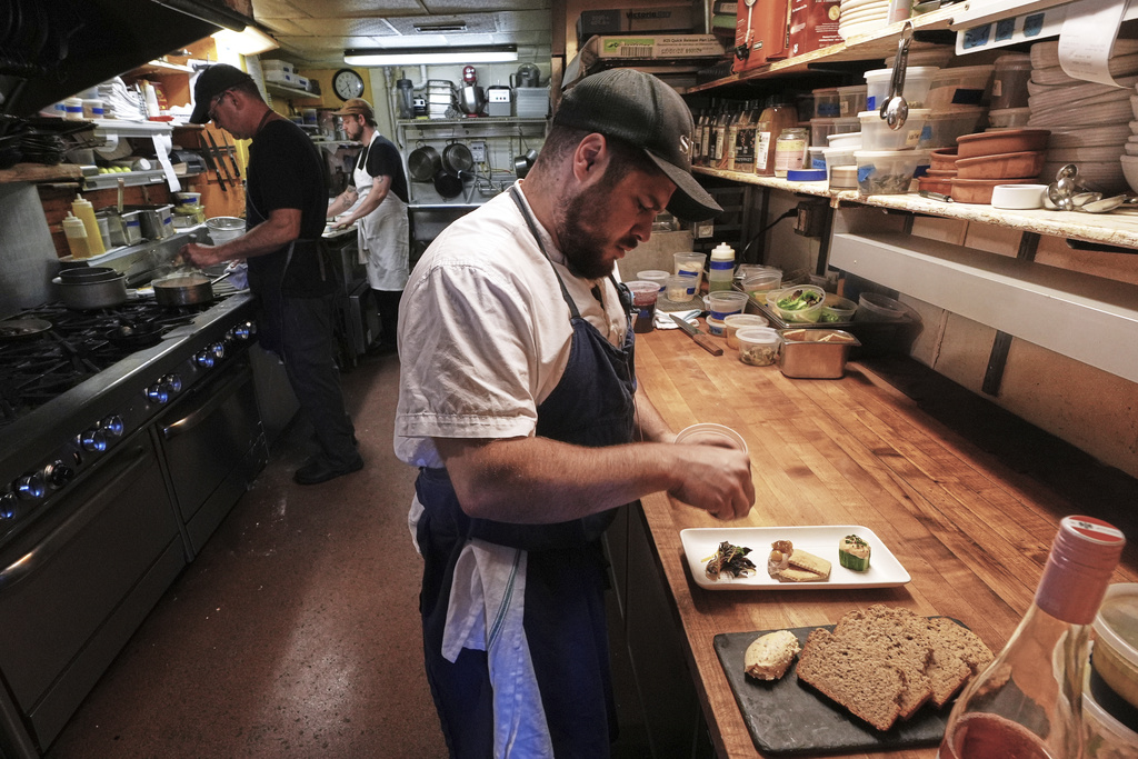 Chef Jake Vatalaro sprinkles locally foraged locust flower seasoning on a Chef