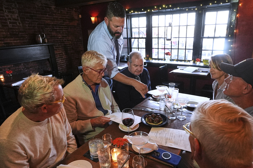 Jon Plaza explains the locally foraged ingredients of the Lebanese lamb meatball appetizer to a group dining at the Black Trumpet restaurant in Portsmouth, N.H.