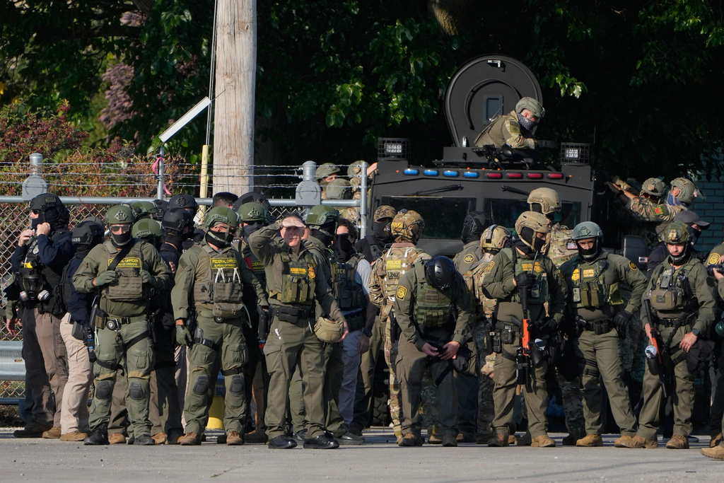 Greg Bovino, the chief patrol agent for the U.S. Border Patrol El Centro sector, center, stands with federal immigration agents near an Immigration and Customs Enforcement facility in Broadview, Ill.