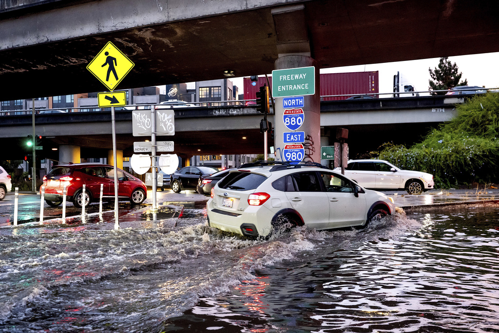 Car traverses a flooded freeway ramp in Oakland, Calif. flood 