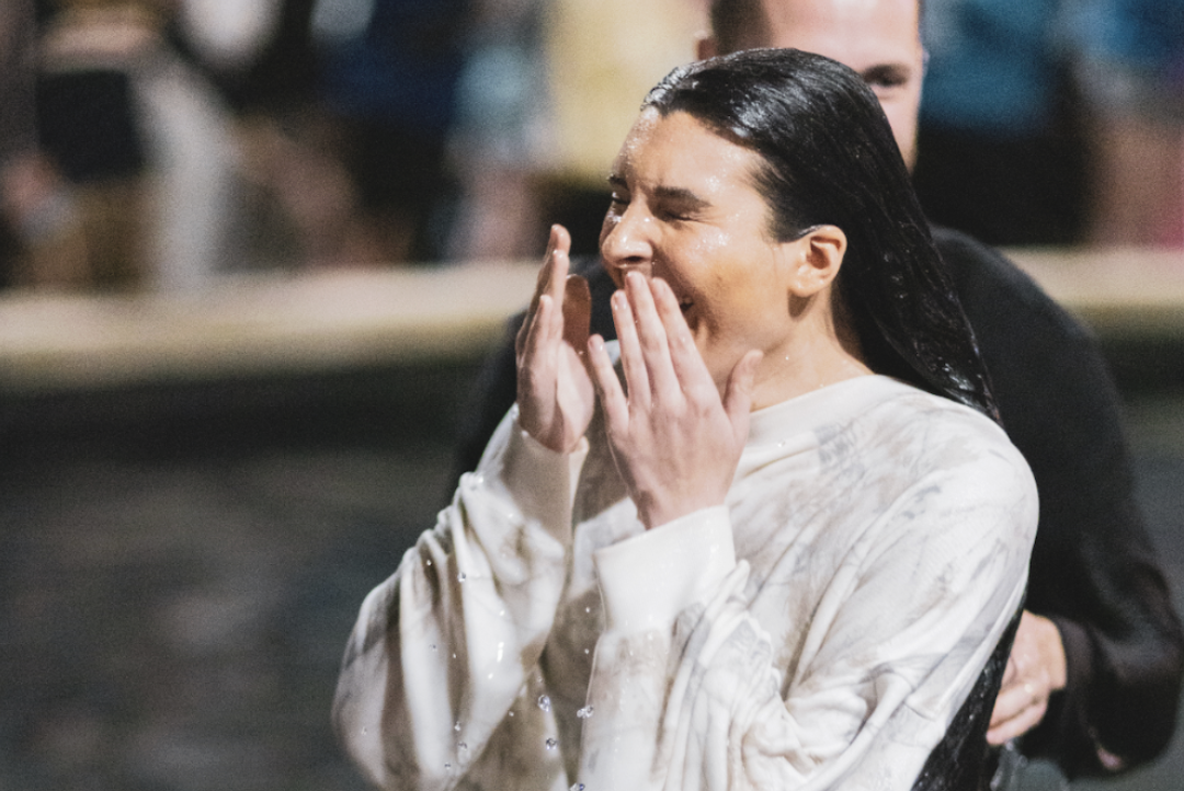 Young woman coming out of the water at her baptism