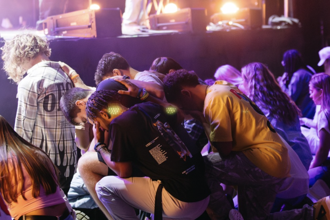 Young people bowed down in prayer