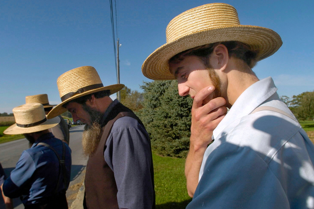 Amish men gather across the street from the one-room schoolhouse in Nickel Mines, Pa., after a fatal shooting at the school