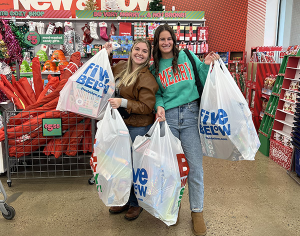Zoe Burnick poses with another volunteer as they pick up toys and supplies for the holiday toy drive