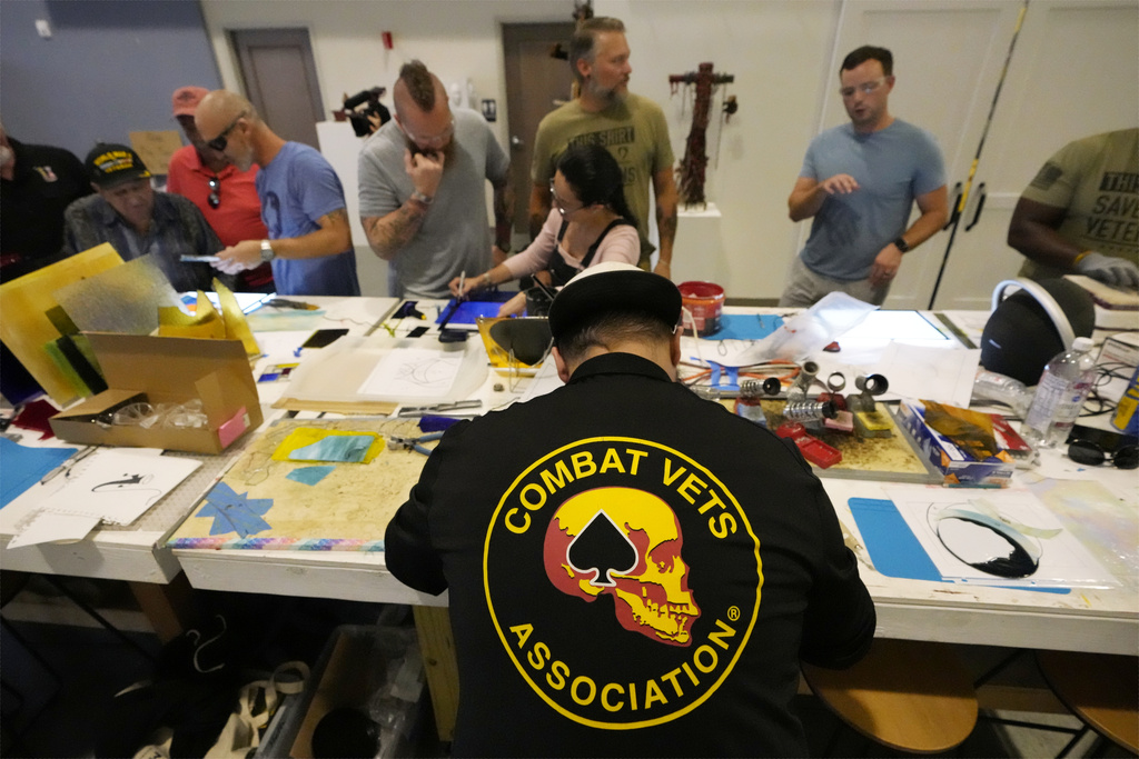Army veteran Charles Elliott, bottom center, works on a piece of stained glass in the CreatiVets headquarters in Nashville, Tenn.