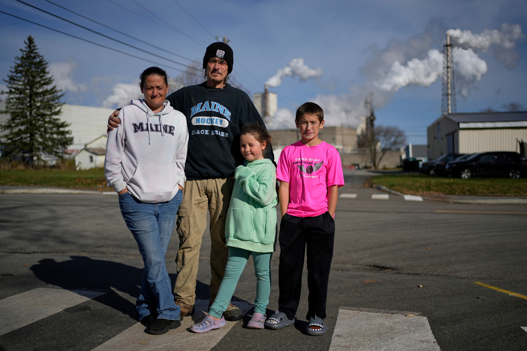 Gerard Berry with his wife Stephanie, and children Brooklynn and Aidan, pose near the Woodland Pulp mill during a walk in their neighborhood in Baileyville, Maine