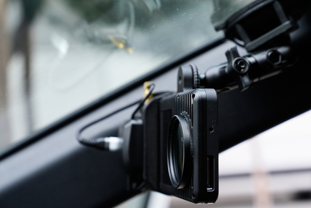 A small detection camera – which uses AI to detect road hazards and potholes – is seen mounted inside a parking enforcement vehicle