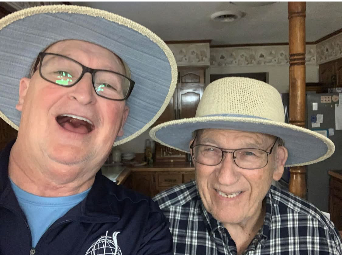 Two smiling men in hats and glasses