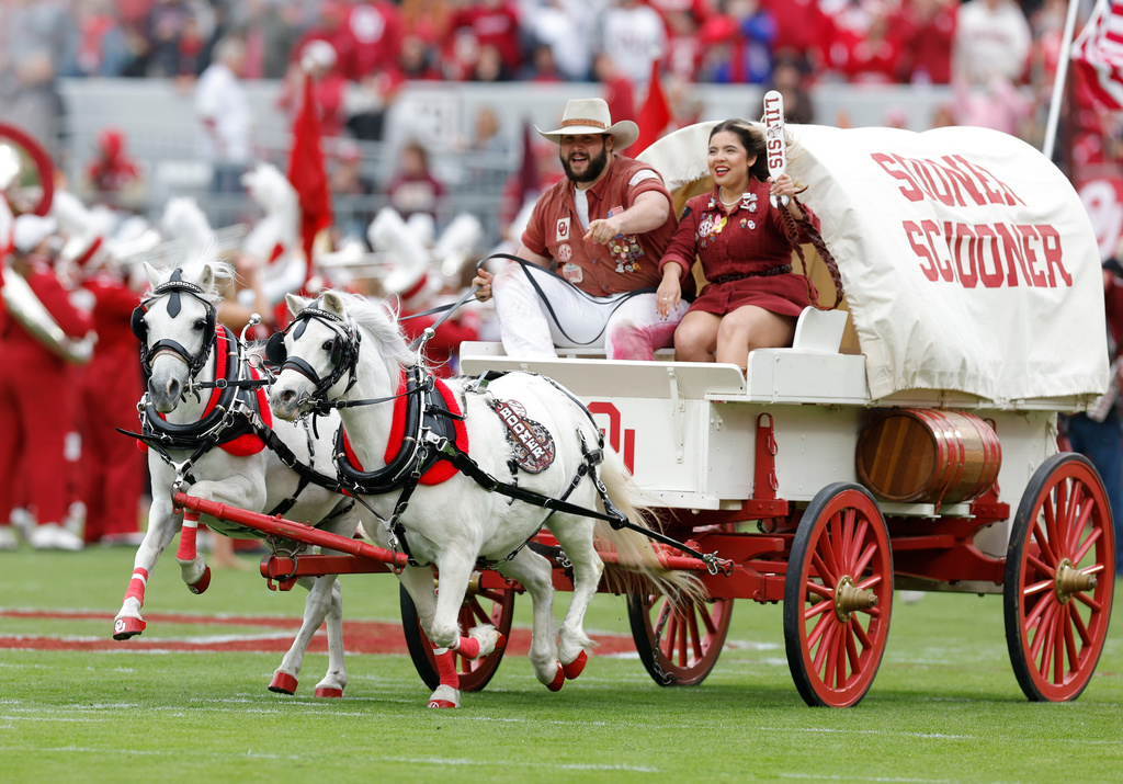Members of the Oklahoma Spirt groups Ruf Neks and Lil Sis drive the Oklahoma Sooner Schooner across the field during pregame of an NCAA college football game between Missouri and Oklahoma 
