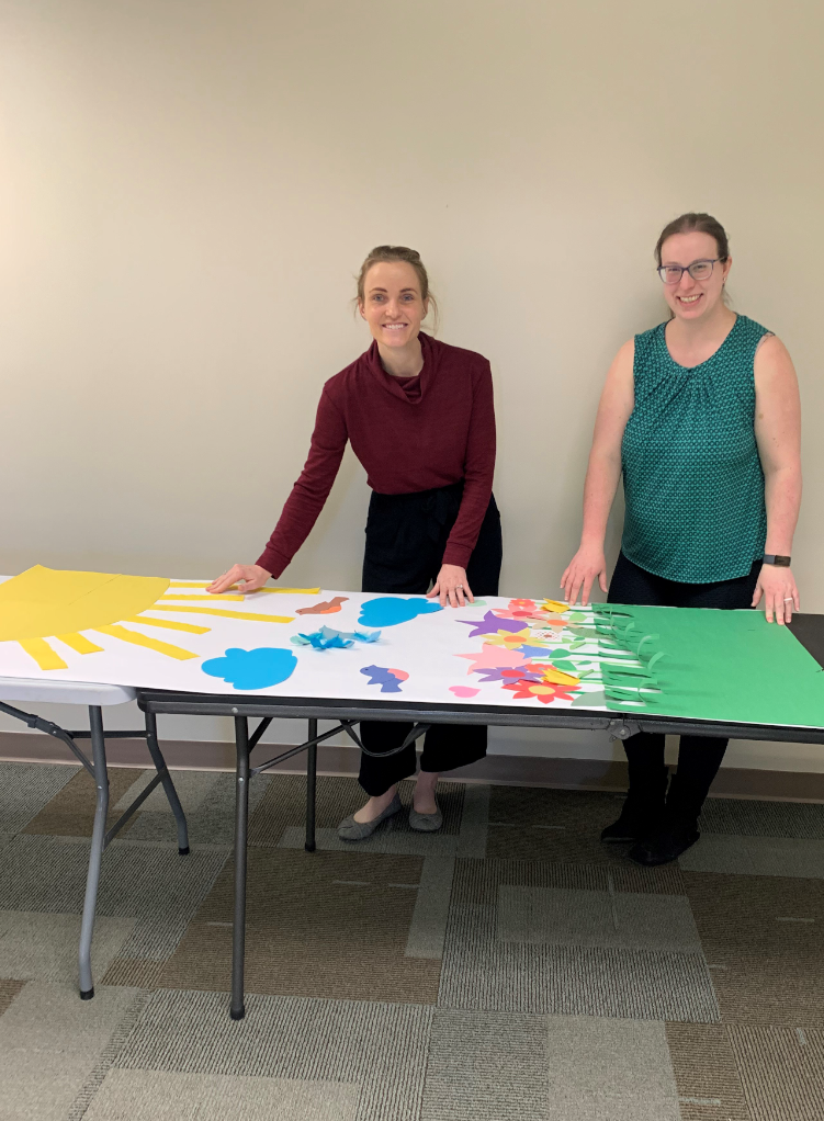 Danielle Shearer poses with another volunteer as they make a door decoration for Ronald McDonald House