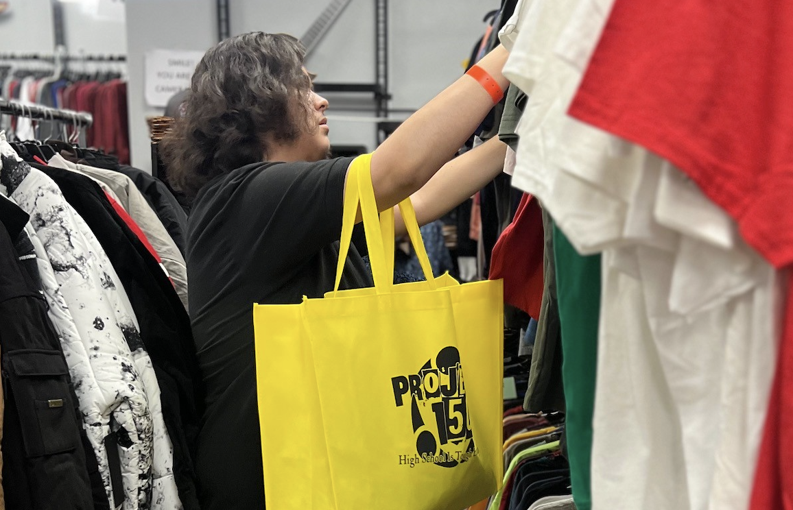 Young person shopping with yellow Project 150 bag