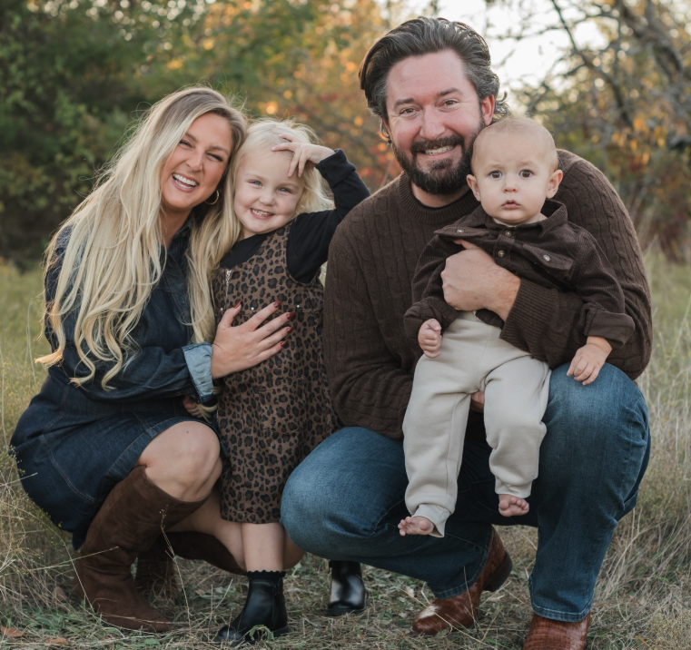 Woman and man, smiling with a baby and a toddler outside