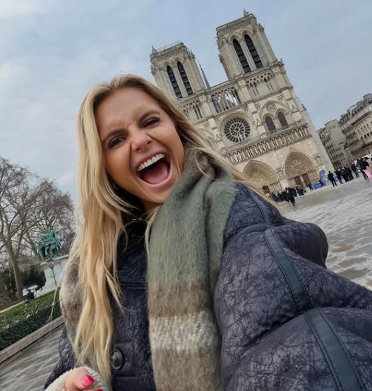 Smiling woman outside in Paris with long, blond hair