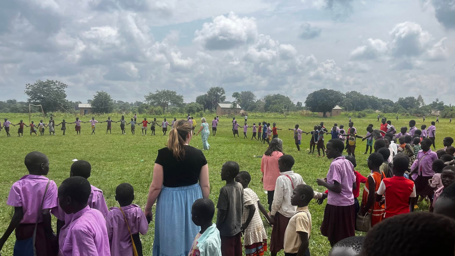Epperson joins hands with children she served on her most recent mission trip to Africa.