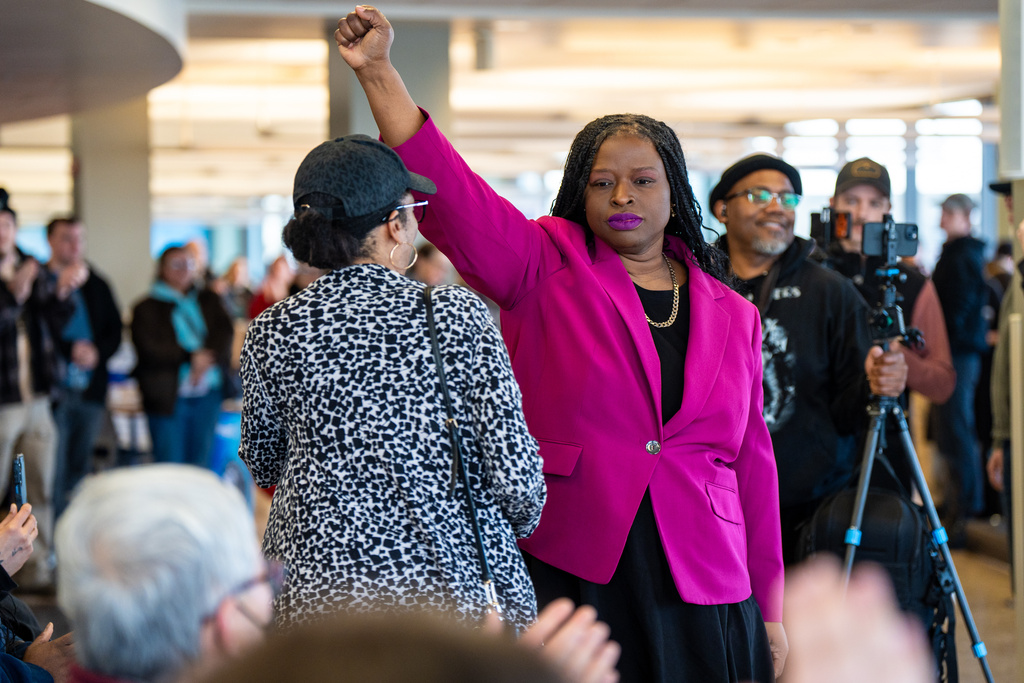 Nekima Levy Armstrong holds up her fist after speaking at an anti-ICE rally 