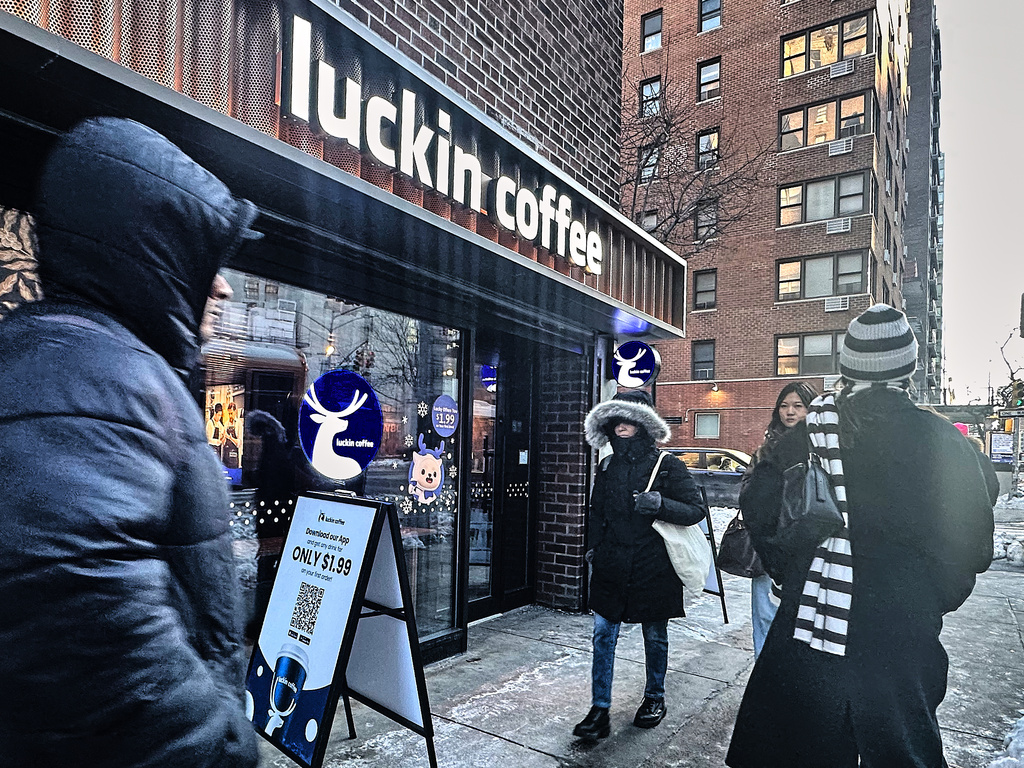 Pedestrians pass a Luckin Coffee store in New York