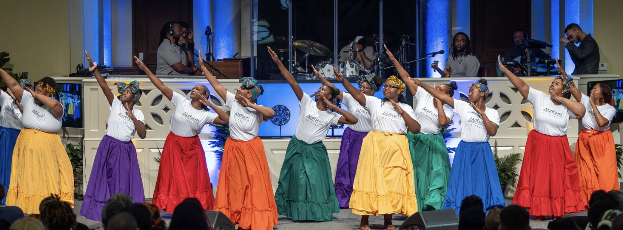 Women in colorful skirts and white shirts, dancing