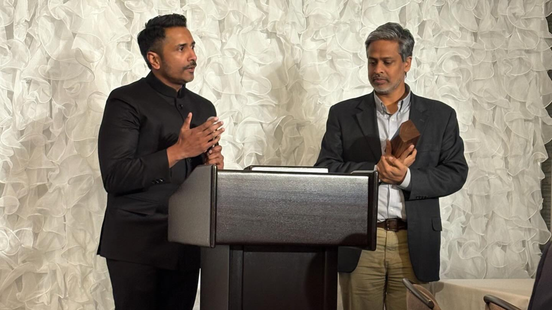Robin John (left) speaks alongside his co-founder Finny Kuruvilla (right) and Eventide Investments annual awards banquet.