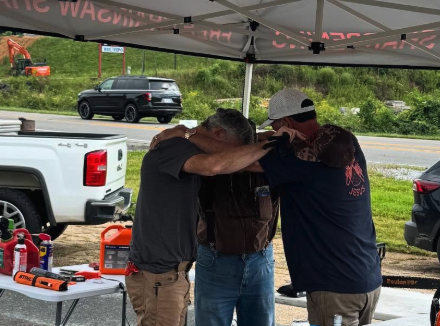 Men praying under tent
