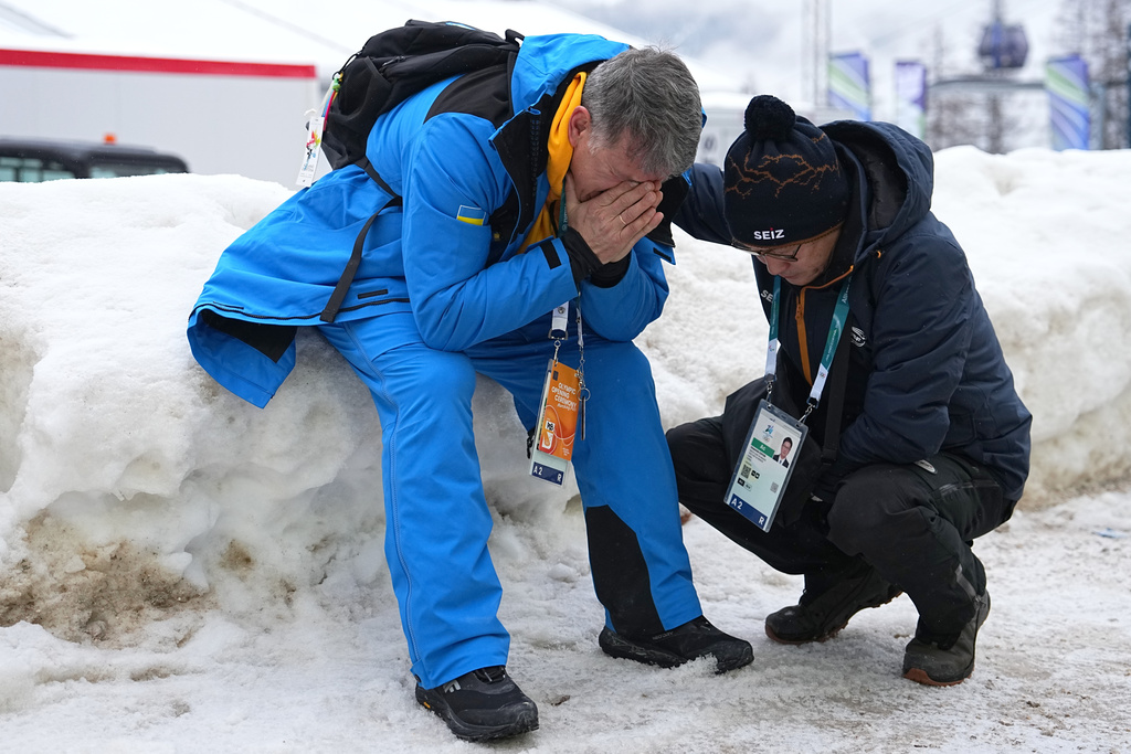 Mykhailo Heraskevych, father of Ukrainian skeleton athlete Vladyslav Heraskevych, reacts as he sits next to the start house of the sliding center at the 2026 Winter Olympics