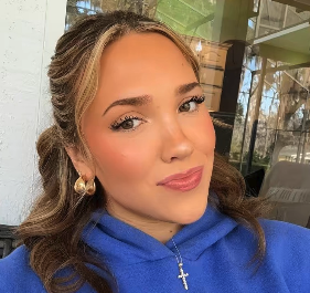 Smiling young lady with cross and blue sweatshirt