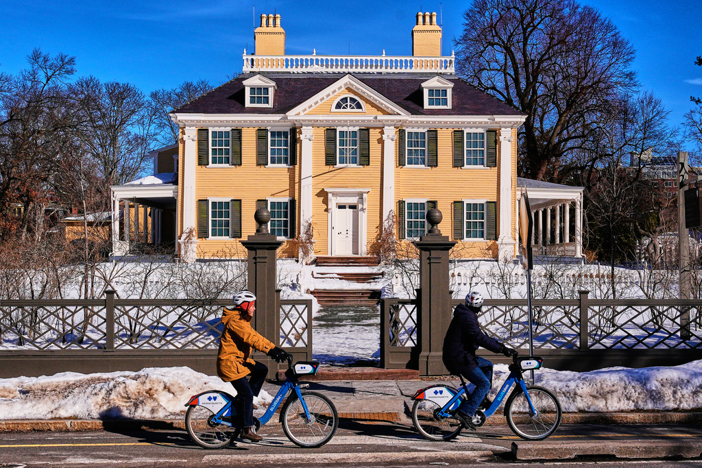 Cyclists pass the Longfellow House, which was George Washington