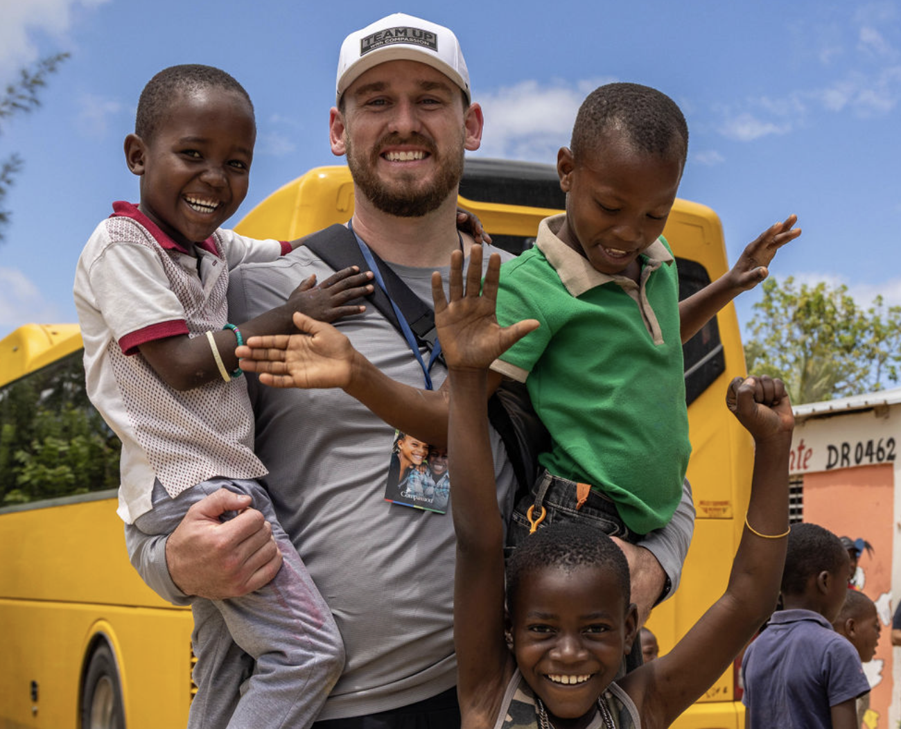 Man holding two young boys with a little girl in front of him