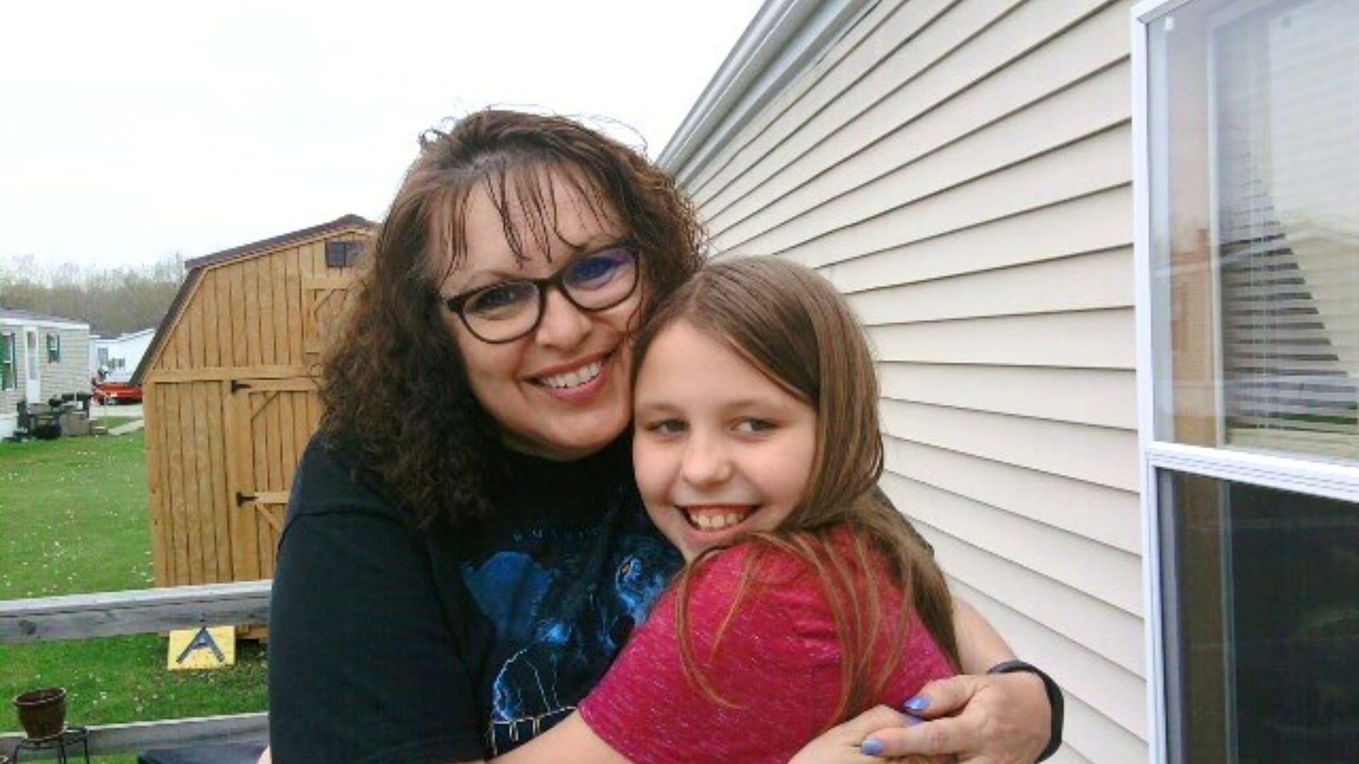 Big Sister Briana and Little Sister Makia share a hug in 2016.