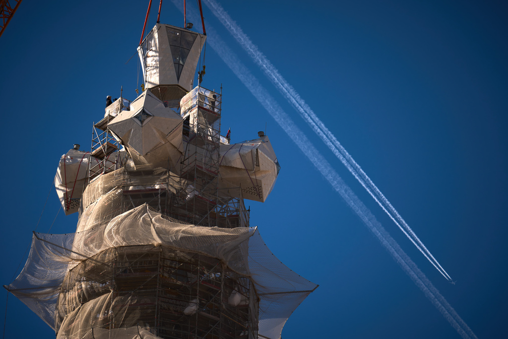 A crane lifts the upper arm of the cross onto the Tower of Jesus Christ at the Sagrada Familia in Barcelona, Spain