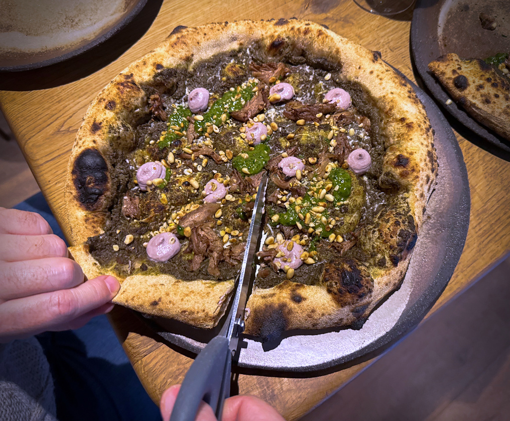 A customer cuts a Roman-era pizza