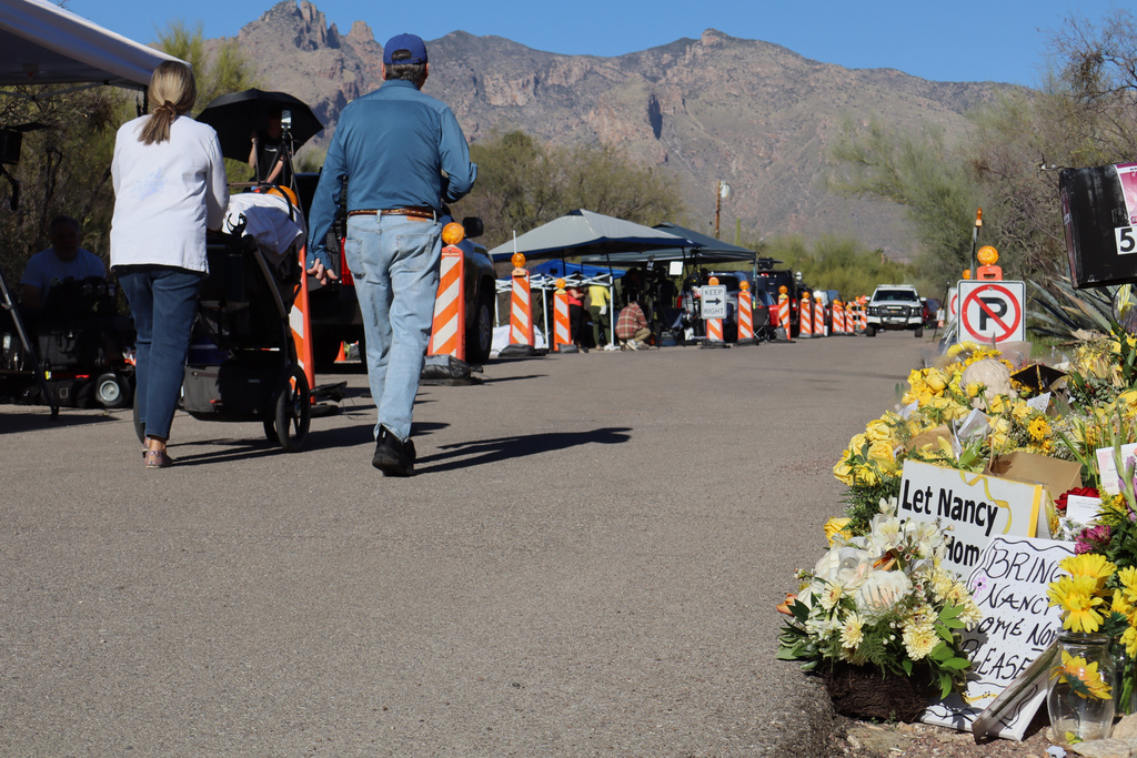 Neighbors walk by a growing memorial for Nancy Guthrie, the missing mother of "Today" show host Savannah Guthrie