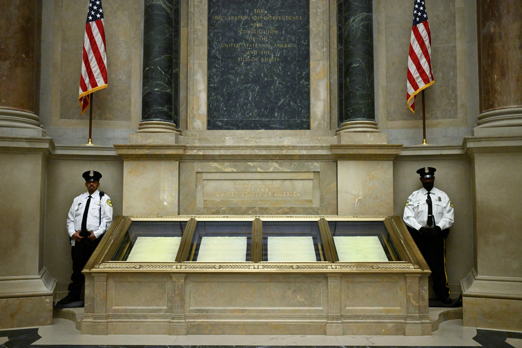 Two guards stand their posts at the cases containing the United States Constitution at the National Archives 