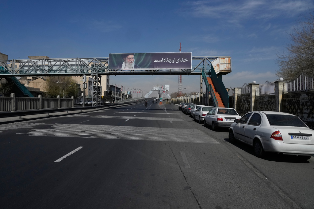 A billboard shows a portrait of the late Iranian Supreme Leader Ayatollah Ali Khamenei, who was killed during ongoing joint U.S.-Israeli military strikes, and the words in Farsi: "His God is alive," in Tehran